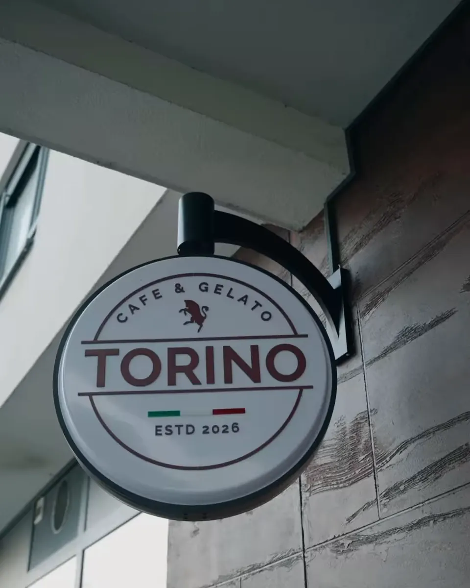 Okrugli TORINO znak na fasadi iznad ulaza u kafić